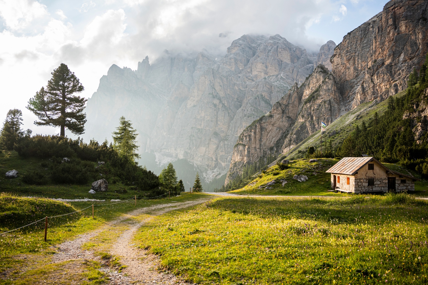 Dřevěná chatka pod skalními stěnami Dolomit — autorská krajinářská fotografie
