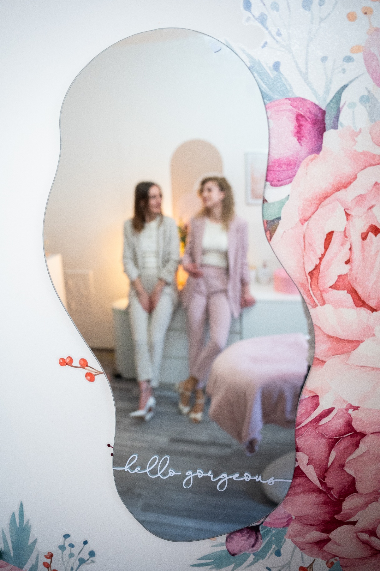 Terka a Linda v odraze designového zrcadla s nápisem hello gorgeous