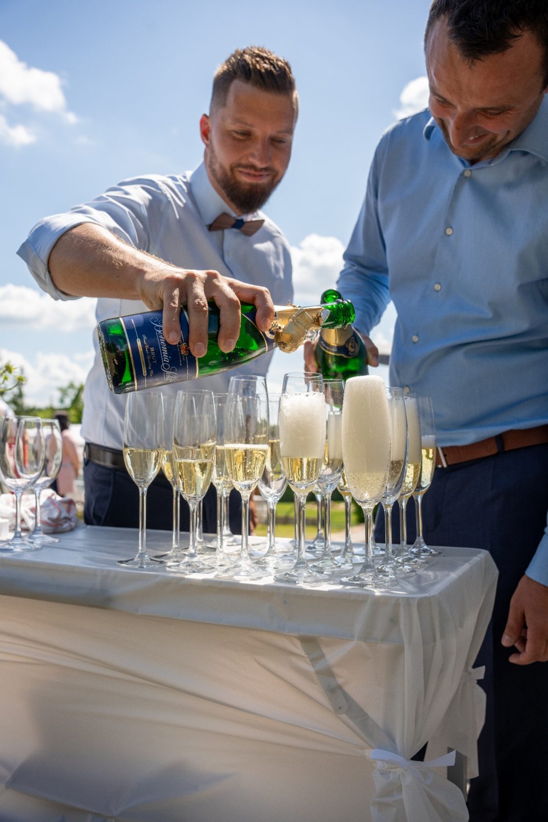 Svědci nalévají sekt do sklenic pro svatební přípitek — Dům NEO, Vysočina